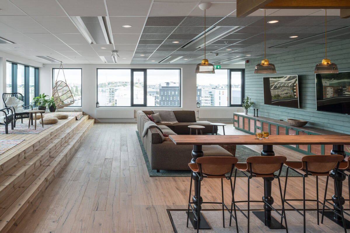 Modern lounge i öppen planlösning med trägolv, en sektionssoffa, barstolar, hängstol och stora fönster med utsikt över staden - stilfulla lösningar för ett bekvämt stadsliv.
