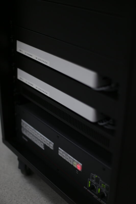 En närbild på två nätverksenheter och en kontrollpanel monterade i ett svart serverrack, som visar upp robusta IT-lösningar.